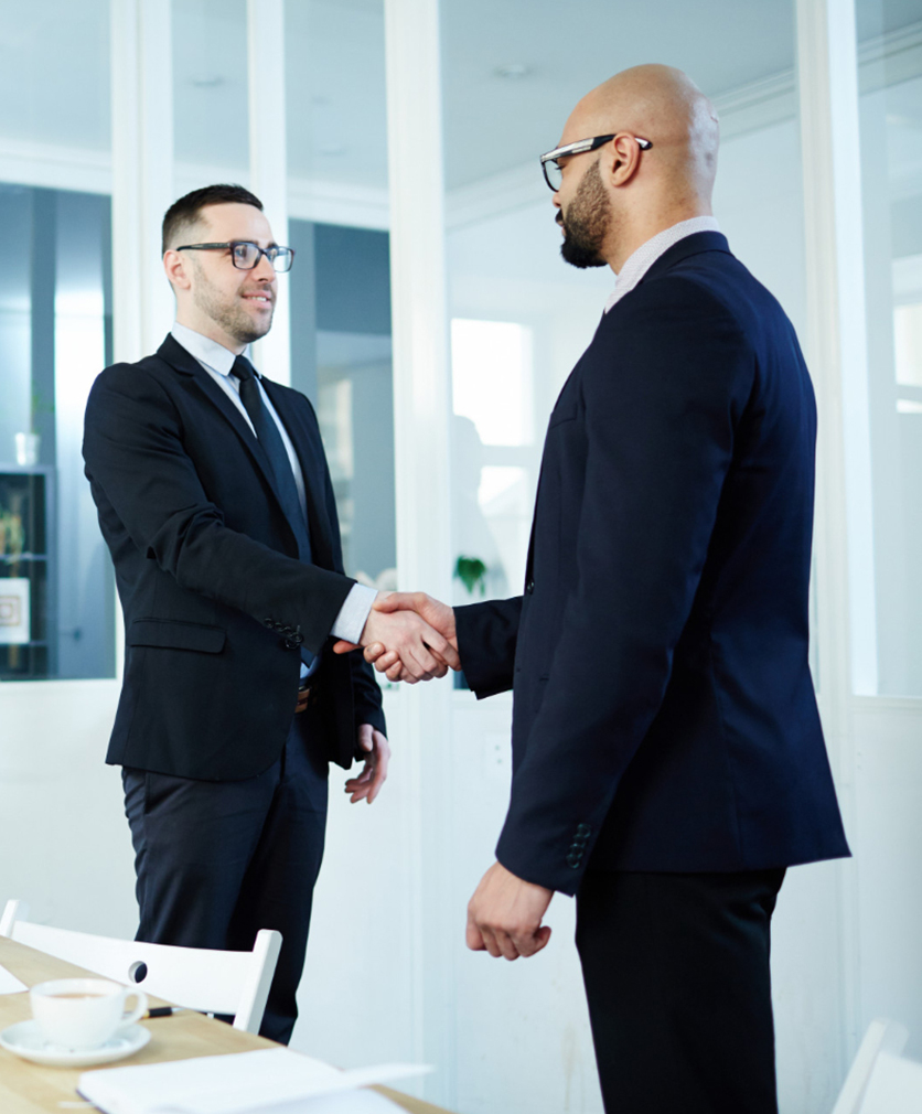 Employee hired shaking hand with employer after interview